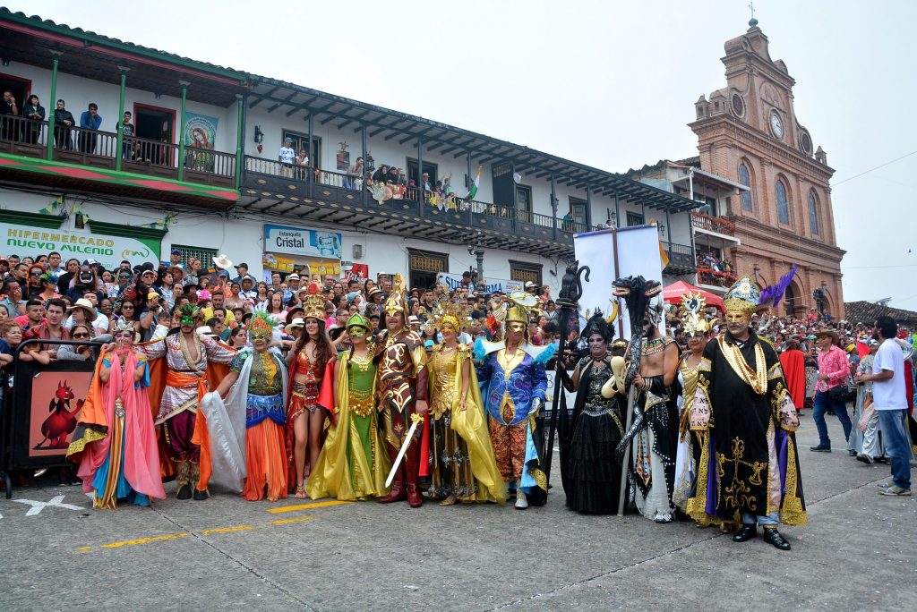 Dos comparsas con trajes coloridos de plumas y máscaras doradas durante el desfile del carnaval