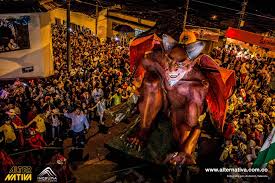 Desfile nocturno del carnaval con multitudes y carroza del diablo iluminada